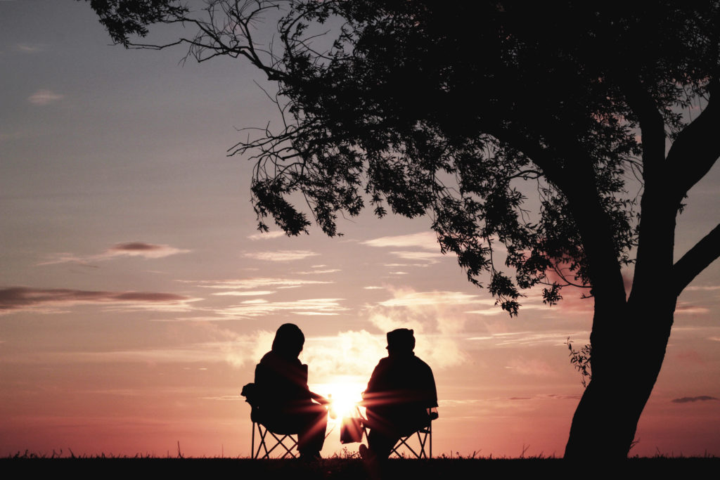 Two people discuss their irrevocable trust as the sun sets in the background.